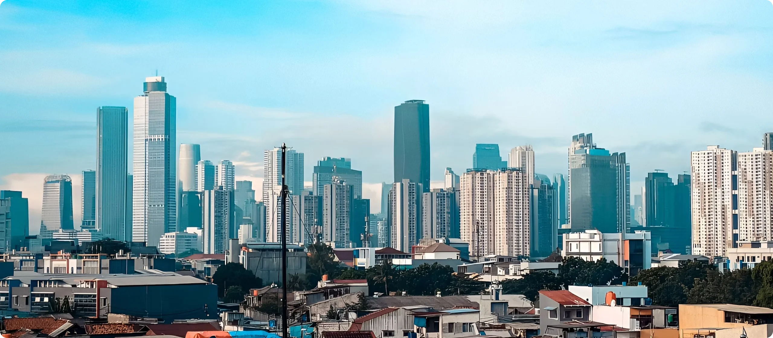 The Jakarta skyline under a blue sky.